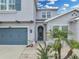 Charming two-story home with a blue garage door, well-manicured lawn, and lush landscaping on a sunny day at 1696 Hidden Springs Dr, Trinity, FL 34655
