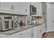 Close-up of kitchen with granite countertops, appliances, and white cabinets at 1696 Hidden Springs Dr, Trinity, FL 34655
