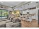 Open-concept living room with comfortable seating and bright kitchen in the background at 1696 Hidden Springs Dr, Trinity, FL 34655
