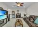 Spacious living room with cozy fireplace, ceiling fan, and comfortable leather seating at 1696 Hidden Springs Dr, Trinity, FL 34655