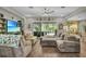 Spacious living room with coastal decor, a large sectional, and view of the pool area at 1696 Hidden Springs Dr, Trinity, FL 34655