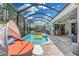 Relaxing screened-in pool with a daybed, outdoor bar, and an inviting atmosphere for leisure and entertaining at 1696 Hidden Springs Dr, Trinity, FL 34655