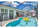 Inviting screened-in pool area with plenty of room for entertaining and lounging with a yellow pool float at 1696 Hidden Springs Dr, Trinity, FL 34655