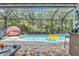 Relaxing screened-in pool area with comfortable seating, colorful decor, and lush backyard views at 1696 Hidden Springs Dr, Trinity, FL 34655