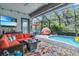 Enjoy indoor/outdoor living in this screened-in pool area with TV, comfortable seating, and easy access to the outdoors at 1696 Hidden Springs Dr, Trinity, FL 34655