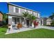 Two-story home boasting a grey exterior, complemented by tropical plants, white rock and a manicured lawn at 1712 Crossvine Ct, Trinity, FL 34655