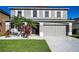 Two-story home featuring a grey color, manicured lawn, complemented by white rock and elegant tropical plants at 1712 Crossvine Ct, Trinity, FL 34655