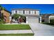 Two-story home featuring a grey color, manicured lawn, complemented by white rock and elegant tropical plants at 1712 Crossvine Ct, Trinity, FL 34655