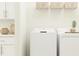 Functional laundry room with modern washer, dryer, white cabinets, and shelf decor at 17518 Happytrails St, Land O Lakes, FL 34638