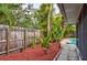 Fenced backyard with lush landscaping and a glimpse of the swimming pool at 1955 Cobblestone Way, Clearwater, FL 33760