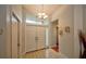 Bright foyer with tile flooring, double doors, and an elegant chandelier at 1955 Cobblestone Way, Clearwater, FL 33760