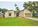 Charming single-story home featuring a well-maintained lawn, two-car garage, and mature landscaping at 1955 Cobblestone Way, Clearwater, FL 33760
