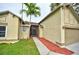 Inviting home featuring a well-manicured lawn, screened entryway, and a two-car garage at 1955 Cobblestone Way, Clearwater, FL 33760