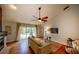 Bright living room with hardwood floors, a ceiling fan, and a view of the pool area at 1955 Cobblestone Way, Clearwater, FL 33760