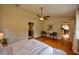 Bright main bedroom boasts wood floors, a ceiling fan, and a convenient layout with ensuite bath and dining area access at 1955 Cobblestone Way, Clearwater, FL 33760