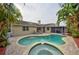 Backyard with in-ground pool, spa, brick pavers and landscaping in a tropical setting at 1955 Cobblestone Way, Clearwater, FL 33760
