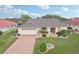 Expansive aerial view of a well-maintained single-story home with a brick driveway and manicured lawn at 1972 Wolf Laurel Dr, Sun City Center, FL 33573