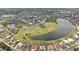 Panoramic aerial view of a neighborhood featuring lush green spaces and sparkling water features at 1972 Wolf Laurel Dr, Sun City Center, FL 33573
