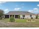 Expansive backyard with mature landscaping, lush green lawn, and a screened-in lanai at 1972 Wolf Laurel Dr, Sun City Center, FL 33573