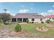 Landscaped backyard featuring a patio, manicured lawn, and decorative rock beds at 1972 Wolf Laurel Dr, Sun City Center, FL 33573
