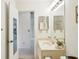 Bright bathroom with a single vanity, a well-lit mirror, and a glimpse into an adjacent room at 1972 Wolf Laurel Dr, Sun City Center, FL 33573