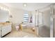 Well-lit bathroom showcases a corner tub, tiled shower, and spacious vanity with generous lighting at 1972 Wolf Laurel Dr, Sun City Center, FL 33573