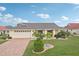 Attractive single-story home showcasing a brick driveway, a two-car garage, and beautifully landscaped front yard at 1972 Wolf Laurel Dr, Sun City Center, FL 33573