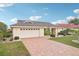 Inviting single-story home with a two-car garage, brick driveway, and meticulously landscaped front yard at 1972 Wolf Laurel Dr, Sun City Center, FL 33573