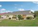 Well-manicured front yard with lush landscaping showcasing a single-story home and brick driveway at 1972 Wolf Laurel Dr, Sun City Center, FL 33573