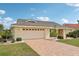 Charming single-story home featuring a two-car garage and a brick driveway in a lush landscaped yard at 1972 Wolf Laurel Dr, Sun City Center, FL 33573