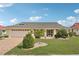 Charming single-story home with a well-manicured lawn and a paved driveway at 1972 Wolf Laurel Dr, Sun City Center, FL 33573