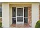 Close-up of a screened entryway with double front doors and decorative stone columns, adding curb appeal at 1972 Wolf Laurel Dr, Sun City Center, FL 33573