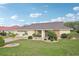 Charming front yard with lush landscaping, mature trees, and a brick-paved driveway at 1972 Wolf Laurel Dr, Sun City Center, FL 33573