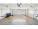 Open garage space featuring a functional door, concrete flooring, and ample room for storage at 1972 Wolf Laurel Dr, Sun City Center, FL 33573