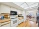 Cozy kitchen boasts wood floors, white cabinetry, and stainless steel microwave and oven at 1972 Wolf Laurel Dr, Sun City Center, FL 33573