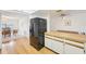Galley kitchen with light wood floors and white cabinets is adjacent to the dining room at 1972 Wolf Laurel Dr, Sun City Center, FL 33573