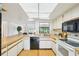 View of kitchen with white appliances, wood floors and access to Gathering room at 1972 Wolf Laurel Dr, Sun City Center, FL 33573
