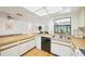 Open-concept kitchen with neutral countertops that connect to a dining and living area at 1972 Wolf Laurel Dr, Sun City Center, FL 33573