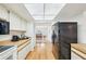 Well-lit kitchen features light wood floors, white cabinets and drawers, with a black refrigerator at 1972 Wolf Laurel Dr, Sun City Center, FL 33573