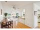Bright living room with white couches and light wood floors next to the kitchen area at 1972 Wolf Laurel Dr, Sun City Center, FL 33573
