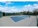 Well-maintained tennis court with a net, fence, and plenty of space for players to enjoy a match at 1972 Wolf Laurel Dr, Sun City Center, FL 33573