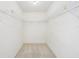 Spacious walk-in closet offers ample storage with multiple shelves and racks at 1972 Wolf Laurel Dr, Sun City Center, FL 33573
