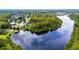 A scenic aerial shot of a community on a lake, surrounded by lush trees, offering a picturesque and serene living environment at 19836 Hidden Glen Dr, Land O Lakes, FL 34638