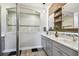 Elegant bathroom with double vanity, stone countertops, decorative mirror and a glass-enclosed shower at 19836 Hidden Glen Dr, Land O Lakes, FL 34638