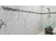 Stylish bathroom shower with marble-style tile and accent mosaic border at 19836 Hidden Glen Dr, Land O Lakes, FL 34638
