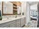 Bright bathroom featuring a double vanity, wooden accents, and seamless access to an adjoining bedroom at 19836 Hidden Glen Dr, Land O Lakes, FL 34638