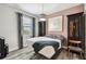 Cozy bedroom with a unique light fixture, stylish curtains, and wood-look flooring at 19836 Hidden Glen Dr, Land O Lakes, FL 34638