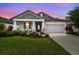 Charming single-Gathering home boasting a well-manicured lawn, vibrant flowers, and neutral gray tones at 19836 Hidden Glen Dr, Land O Lakes, FL 34638