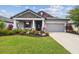 Charming single-Gathering home boasting a well-manicured lawn, vibrant flowers, and neutral gray tones at 19836 Hidden Glen Dr, Land O Lakes, FL 34638