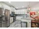 Modern kitchen with stainless appliances, quartz counters, breakfast bar, open to living room at 19836 Hidden Glen Dr, Land O Lakes, FL 34638